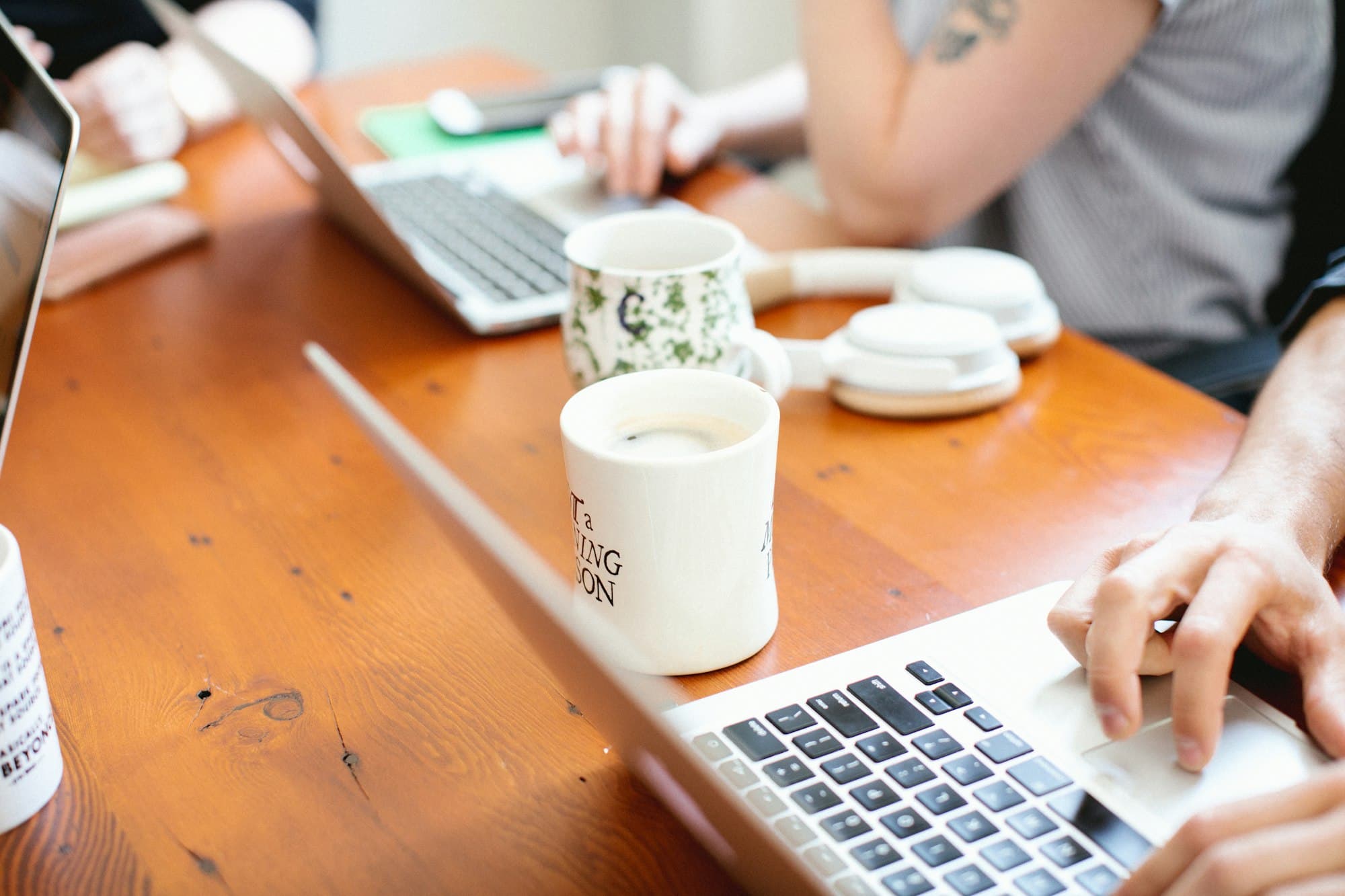 Two people working on laptops at a shared table