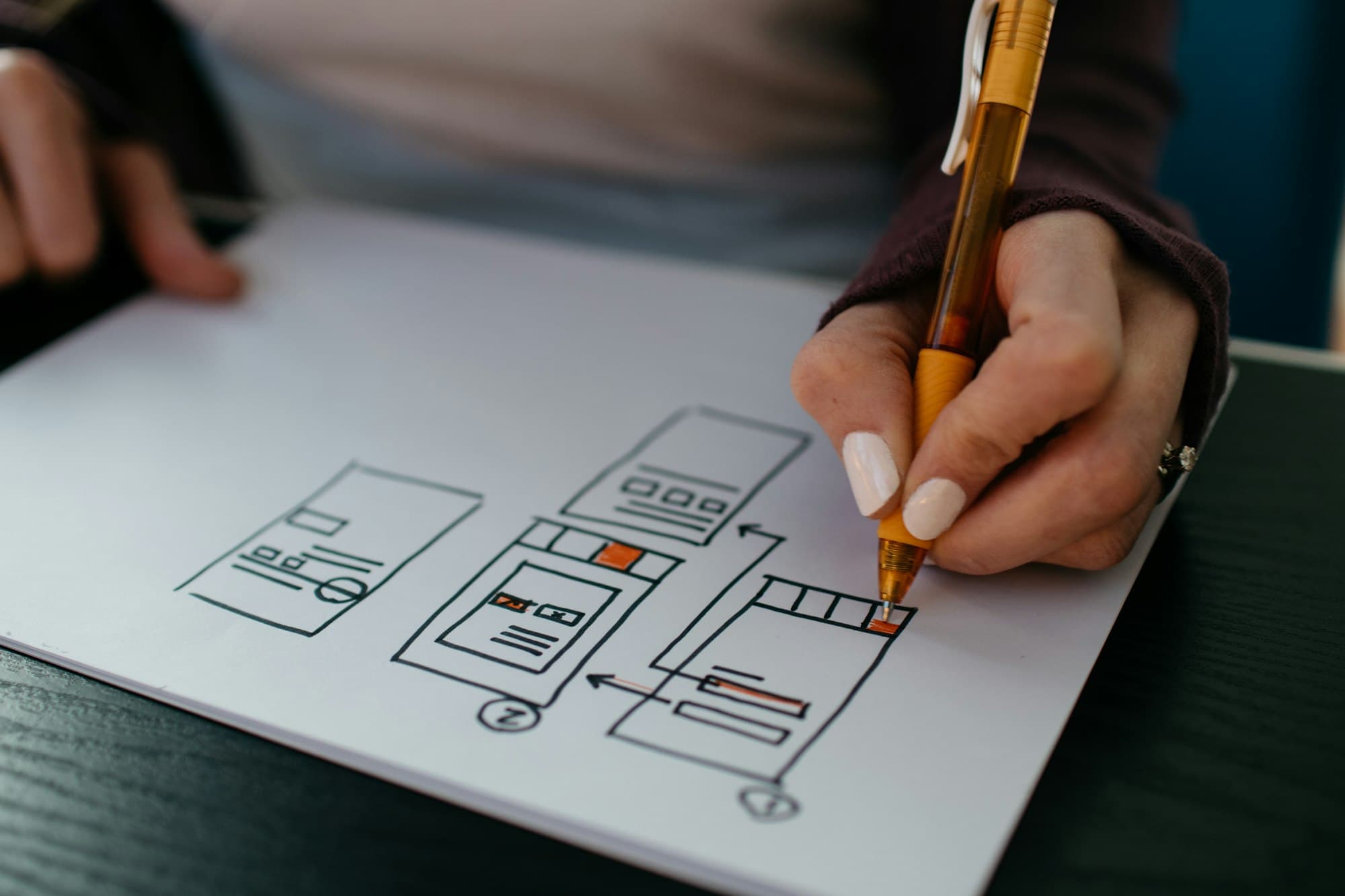 Pen sketching interface wireframes on paper
